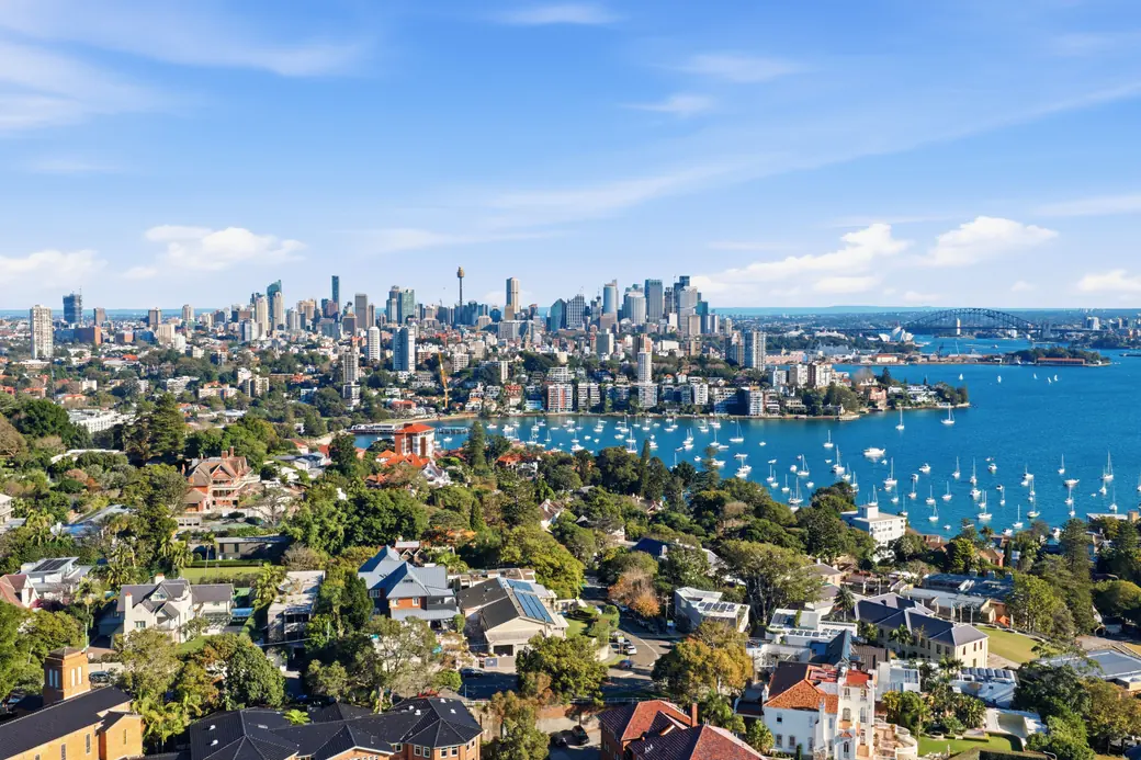 Aerial view across Sydney Harbour to the CBD skyline, with Double Bay moorings in the foreground.
