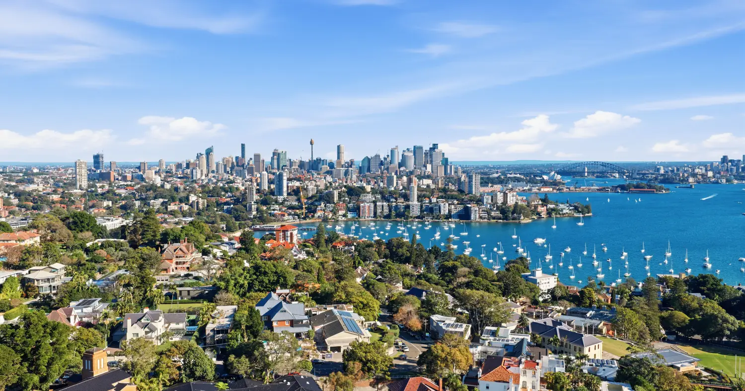 Aerial view across Sydney Harbour to the CBD skyline, with Double Bay moorings in the foreground.